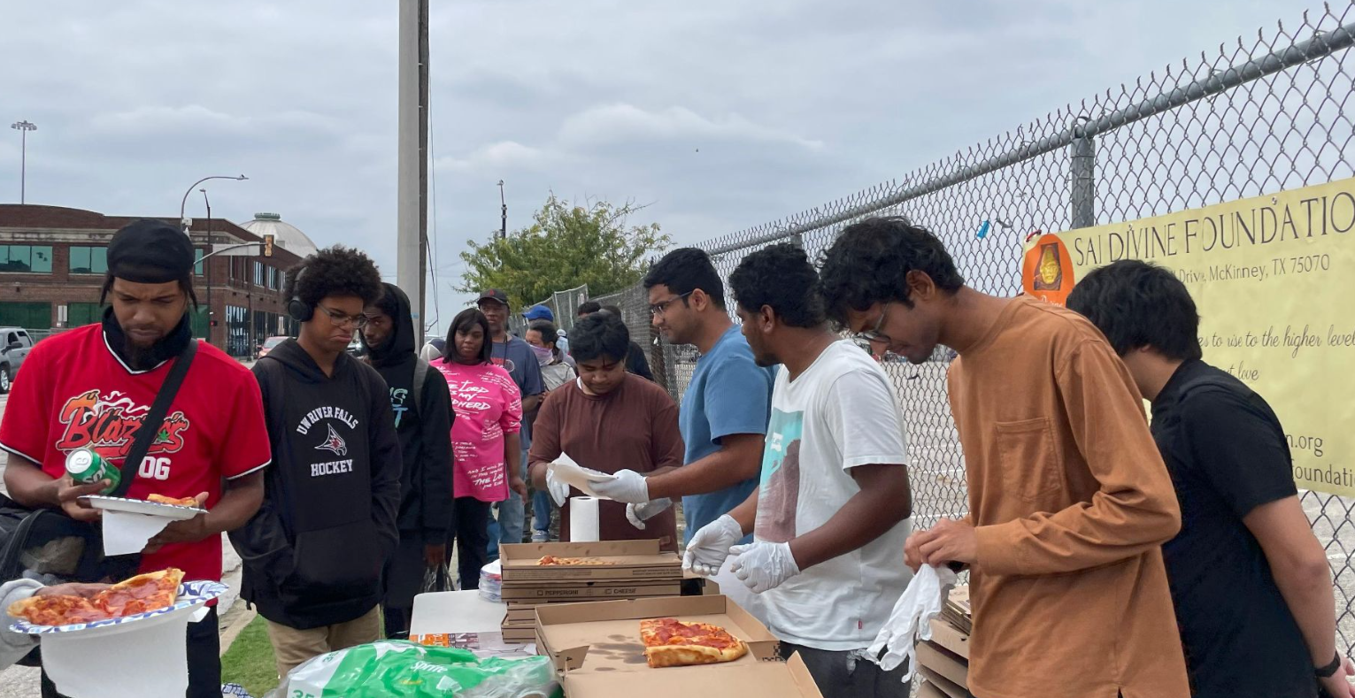 Volunteers serving pizza to community members
